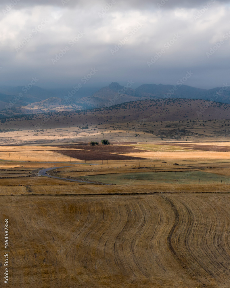 Great nature view, freshly mown crops and foggy mountains with clouds in the background. Emirdag, Turkey.