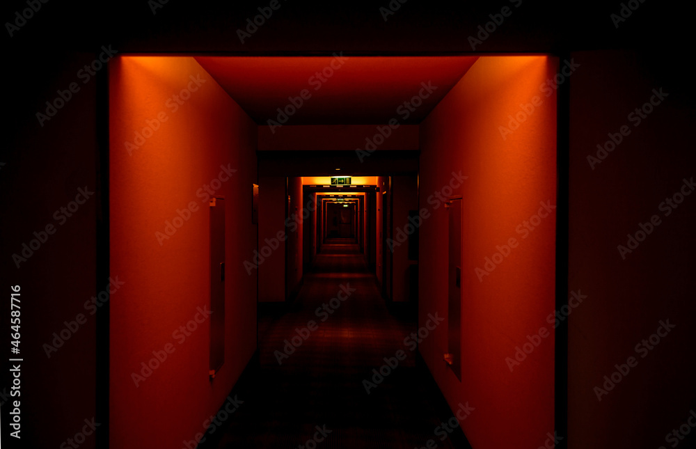 Empty hotel corridor with poor illuminated hall in red color - scary scene Empty hotel corridor with poor illuminated hall in red color - scary scene