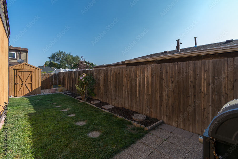 A small, wooden fenced, side yard of a home.