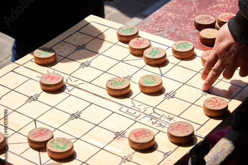 Xiangqi board with some pieces over it. Traditional chinese game. Strategy game between two persons. Men play with a piece of Xiangqi. photo