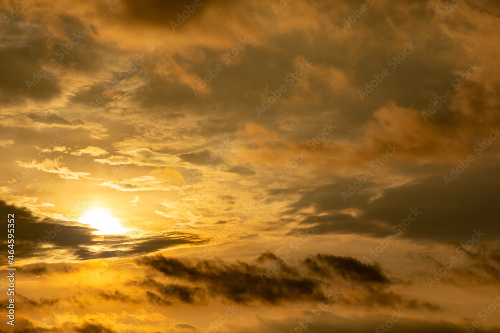 Orange sky with dramatic clouds and rising sun