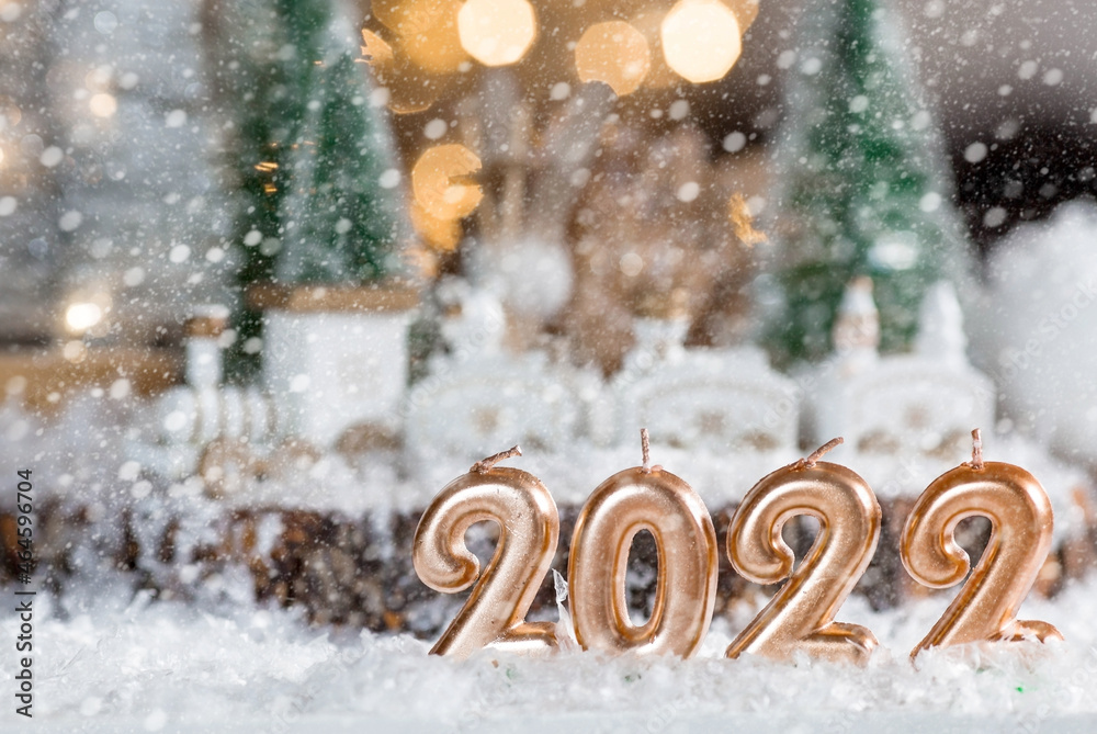 Happy New Year 2022. Beautiful background with candles, Christmas trees, a train and decorations. Celebrating the winter Christmas holidays. The concept of the beginning of the year.