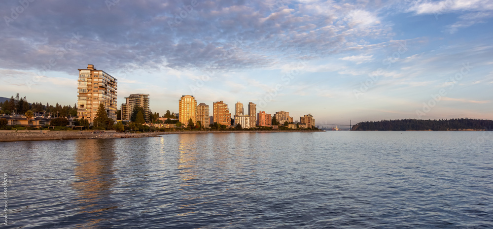 Naklejka premium Walking Trail in a modern city on the West Coast of Pacific Ocean. West Vancouver Centennial Seawalk, British Columbia, Canada. Sunny Summer Sunset.