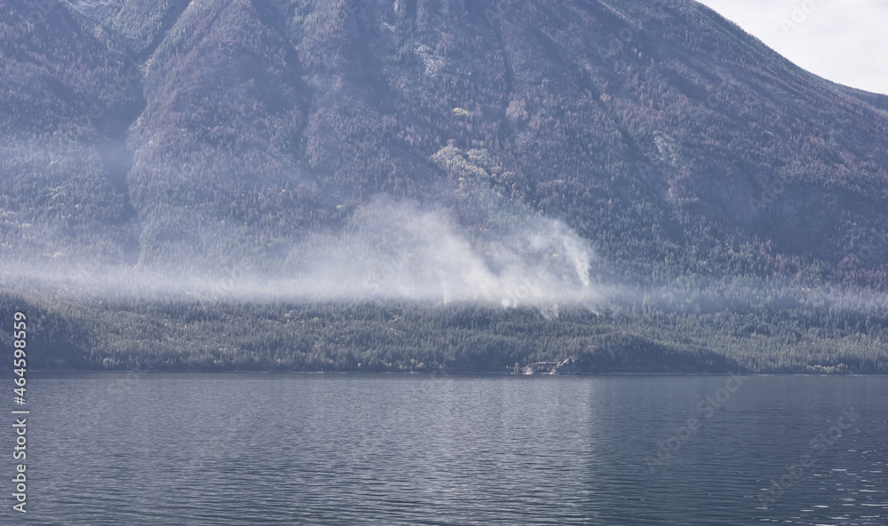 Small Wild Fire on the side of a mountain during a sunny summer day. Interior British Columbia, Canada.