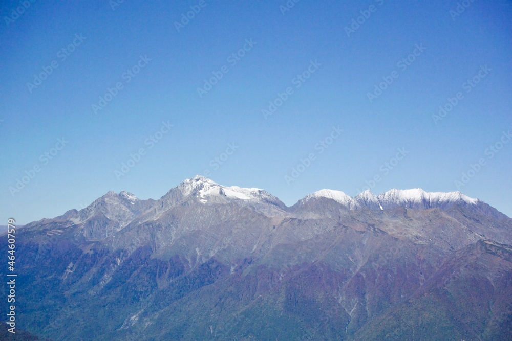 The peaks of the Caucasus mountains covered with snow in the area of the city of Sochi. Russia