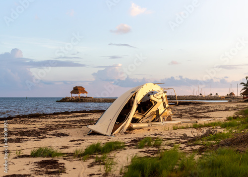 vue d'un bateau à voile échoué sur la plage lors d'un coucher de soleil