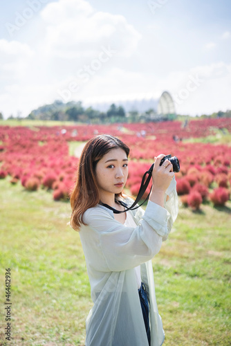 コキアが綺麗な公園で写真を撮るカメラ女子 © peach100