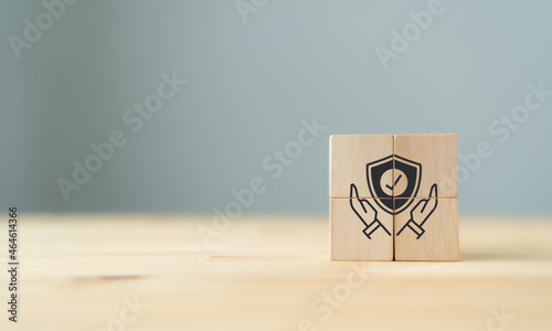 Work safety concept, hazards, protections, health and regulation. Concept of data security. The wooden cubes with hand holding protect shield symbol on grey beautiful background. Copy space.
