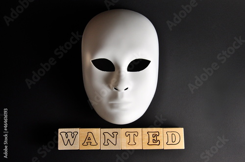 Financial fraud crime. The white mask of a fraudster. The inscription is wanted.