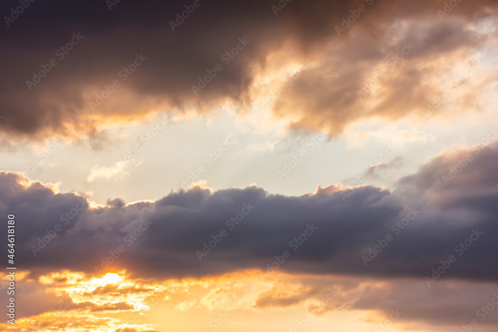 Fototapeta premium The sky at sundown, and thunderclouds. Sunlight streaming through the clouds. Atmospheric photo.