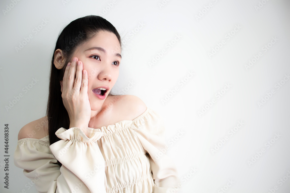 Asian women use hand touch cheek looking something with shocked and surprised face Asian women use hand touch cheek looking something with shocked and surprised face