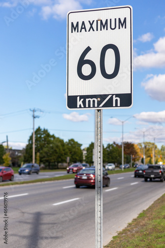 Speed limit road sign against blue sky with clouds, 60 km maximum driving in a street