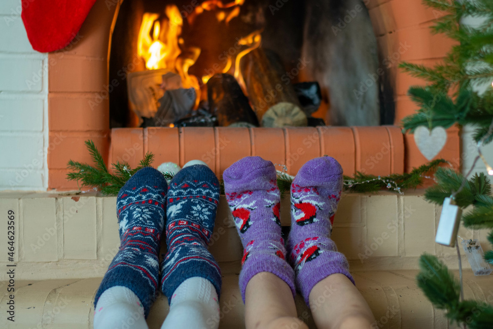 Feet in Christmas socks by the fireplace. Winter Christmas concert.