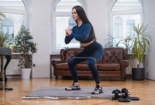 Concentrated woman does yoga with resistance band in apartment photo