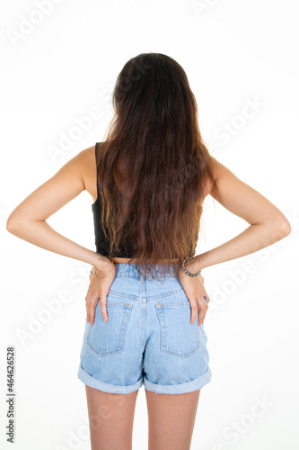 slim beautiful woman in blue short jeans behind rear back view isolated on white