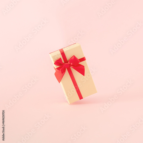 Fototapeta Naklejka Na Ścianę i Meble -  modern abstract christmas gift box in the air  against pastel pink background. futurisam. minimalism. modern creative decoration idea for 2022 new year