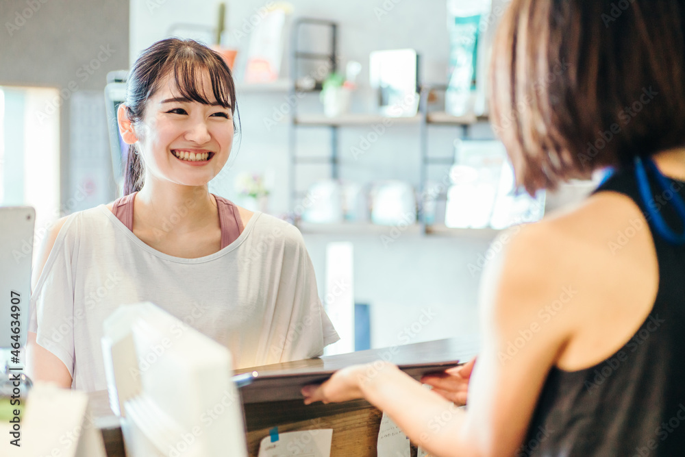 スポーツジムでタブレットを見る女性
