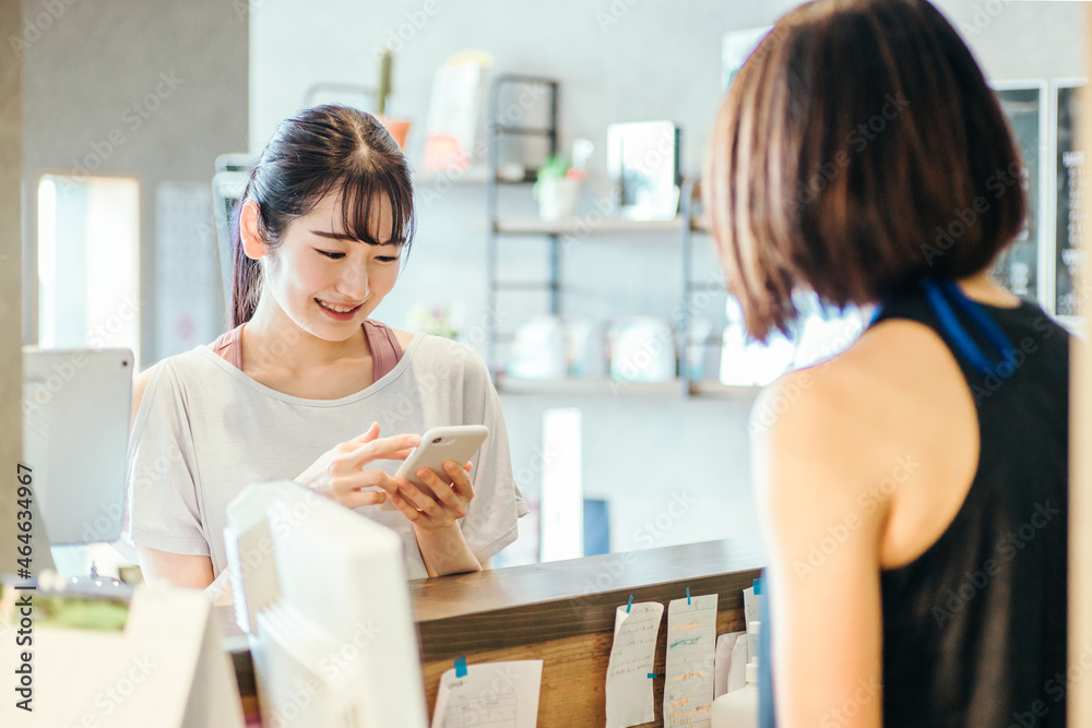 受付でスマホを出す女性
受付でスマホを出す女性