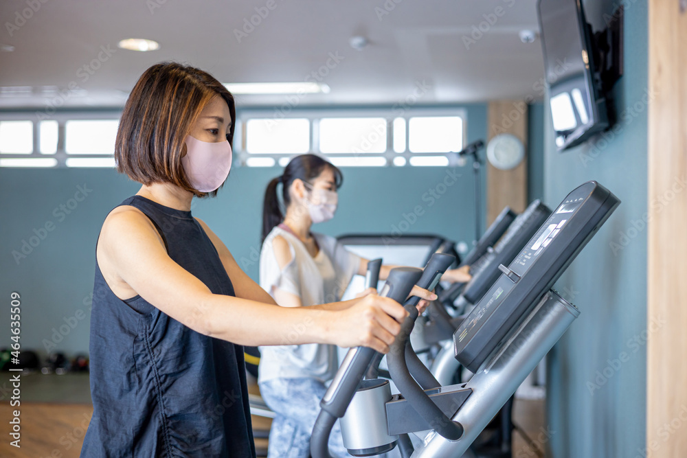 スポーツジムでトレーニングする女性たち(マスク)
スポーツジムでトレーニングする女性たち(マスク)