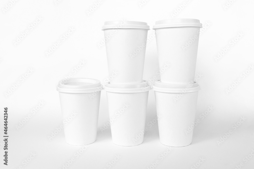 Paper coffee cups with white lids on white backgrounds. Open and closed paper cup. Realistic vector mockup. White cups mock up Paper coffee cups with white lids on white backgrounds. Open and closed paper cup. Realistic vector mockup. White cups mock up
