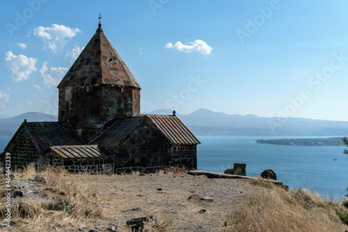 Armenia  Lake Sevan  September 2021. Christian temple of black basalt on the background of the lake.