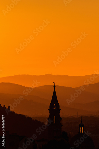 Church tower in the sunset silhouette with mountains in the background