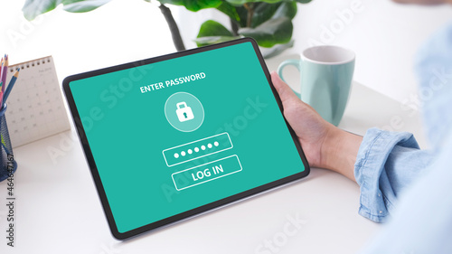 Hand using dogital tablet with password login on screen, cyber security concept