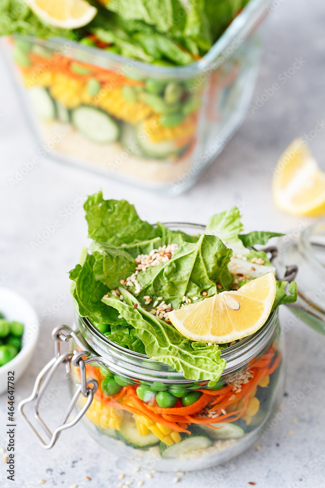 Glass jar with fresh raw vegetables and couscous groats. Healthy Meal Prep - recipe preparation photos. Healthy vegan dishes in glass containers. Weight loss food concept. Salad in a jar.