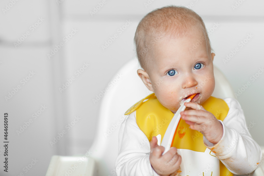 Cute cheerful baby eating in the kitchen Cute cheerful baby eating in the kitchen