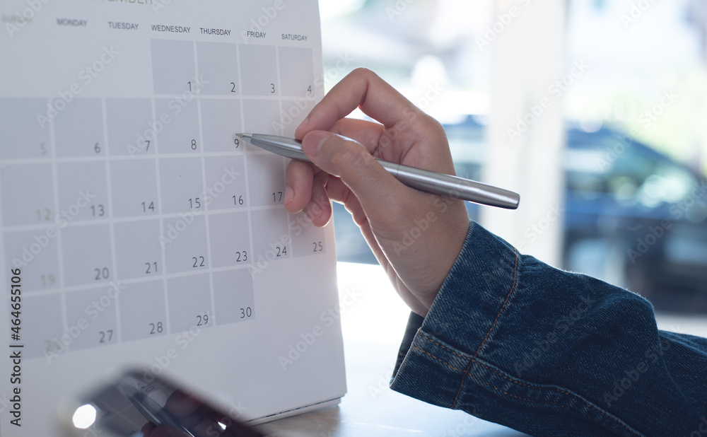 Event planner timetable agenda plan on schedule event. Business woman checking planner on mobile phone, taking note on calendar desk on office table - obrazy, fototapety, plakaty 
