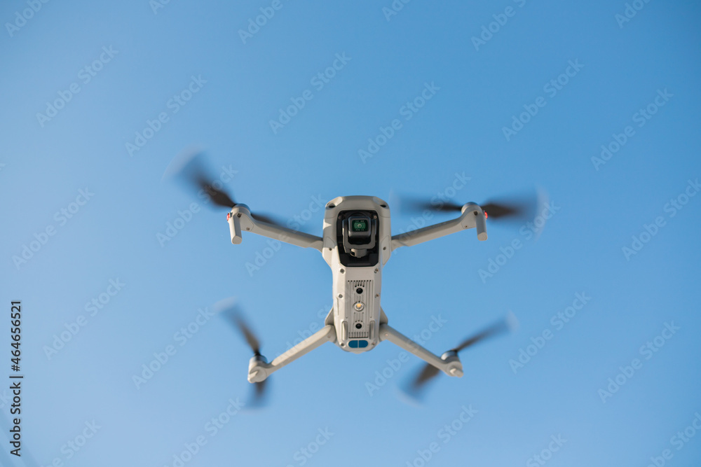 The drone is flying over the ground in a cloudy blue sky. taking pictures from the sky