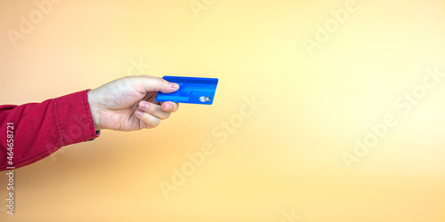 credit card, bank card or Cash card in hand on yellow background. Panorama horizontal. with copy space