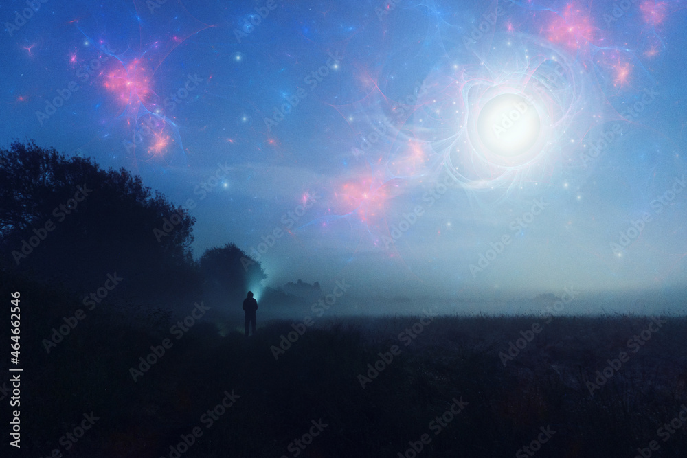 An alien invasion concept. Of glowing UFO's in the night sky with a figure looking up on a misty spooky night.