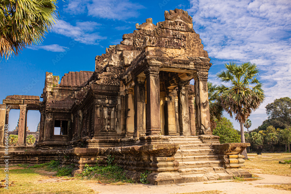 The ancient city of Angkor Wat in Cambodia. Towers of the temple of the Kmer people streets and ruins of houses. Traveling to the sights of ancient civilizations. Stone bas-reliefs on the ruins.