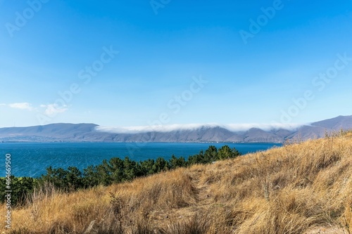 Armenia, Lake Sevan, September 2021. Sun-burnt grass on the slope and a view of the lake.