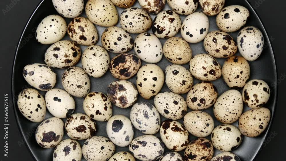 Rotating Quail Eggs On A Black Plate On A Black Background. Top View. Close Up. Rotating Quail Eggs On A Black Plate On A Black Background. Top View. Close Up.