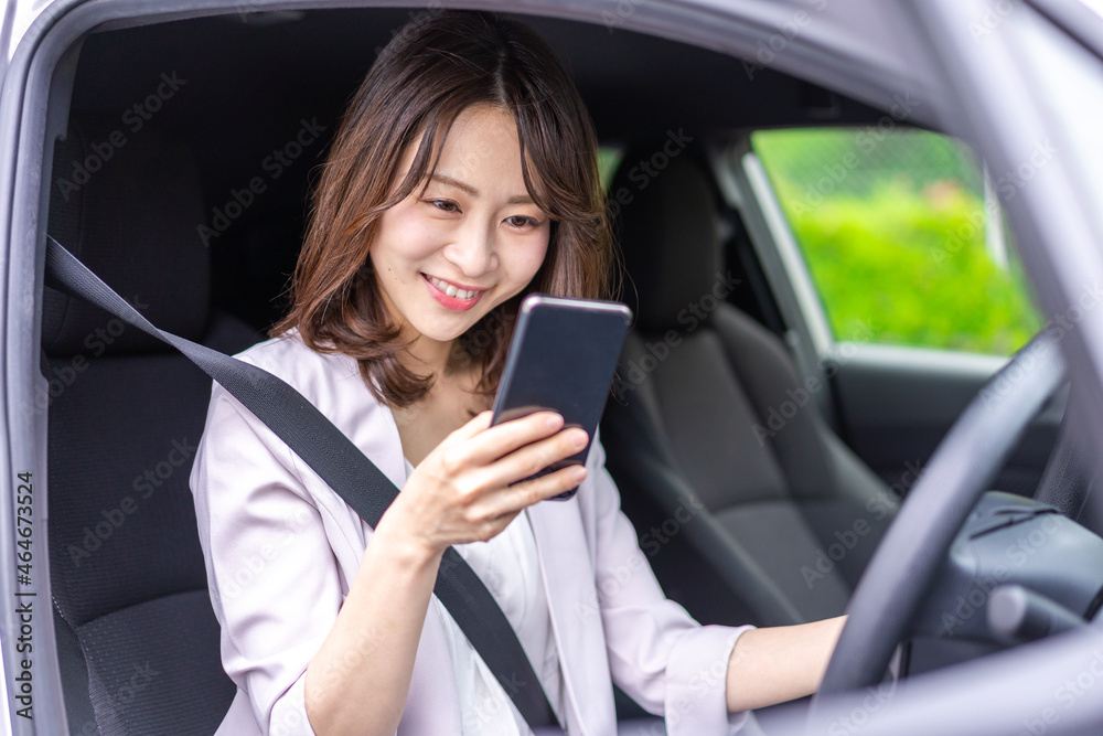 スマホを使いながら車を運転する女性