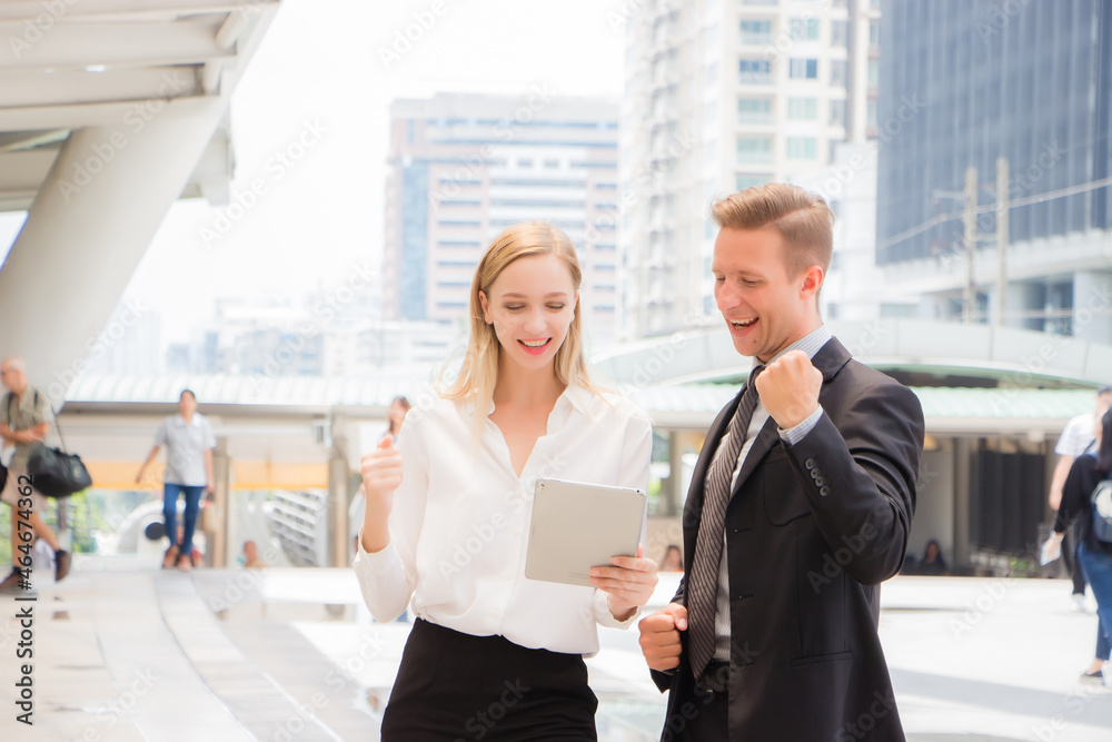 business men and women looking at tablets with joy and happiness business men and women looking at tablets with joy and happiness