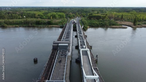 Temse bridge over the river Scheldt seen from above with traffic and cars driving on both side of the road near green trees in summer. Drone aerial bird eye view shot photo