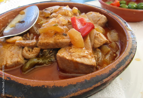 Closeup of dish with traditional spanish andalusian tuna goulash (atun encebollado) with vegetables on table photo
