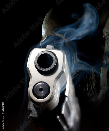 Smoking ghost gun pistol 3D rendering with a skull behind on a black background
