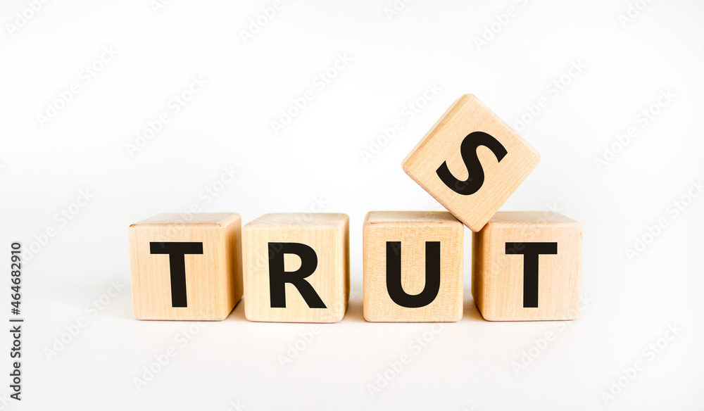 Trust symbol. The concept word 'trust' on wooden cubes. Beautiful white table, white background, copy space. Business and trust concept. Trust symbol. The concept word 'trust' on wooden cubes. Beautiful white table, white background, copy space. Business and trust concept.