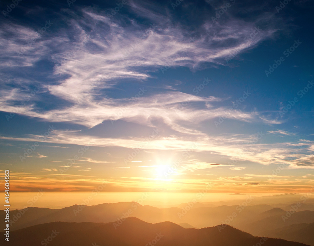 Silhouettes of mountains on background of majestic clouds on sunset sky shine Silhouettes of mountains on background of majestic clouds on sunset sky shine