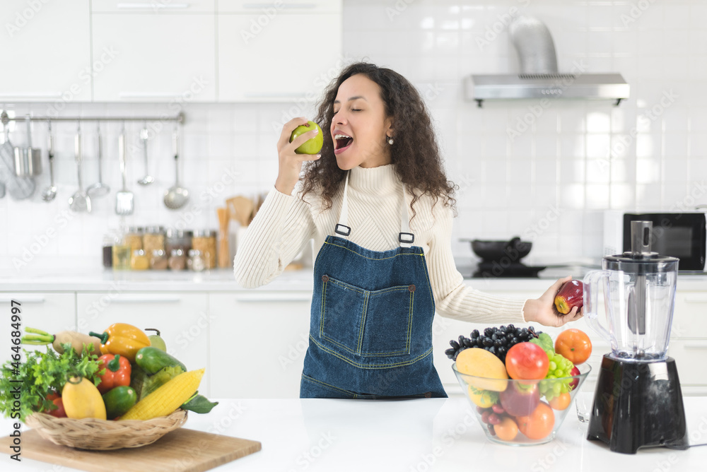 Beautiful woman making fruits smoothies with a blender. Healthy eating lifestyle concept.