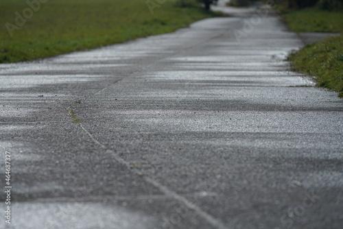 Alte Beton Straße nach einem Regen in tiefer Perspektive, Transport und Bau in ruraler Umgebung