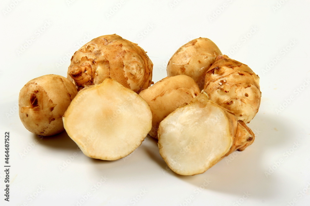 Jerusalem artichoke with white background, close up. Freshly harvested Jerusalem artichoke or topinambur 