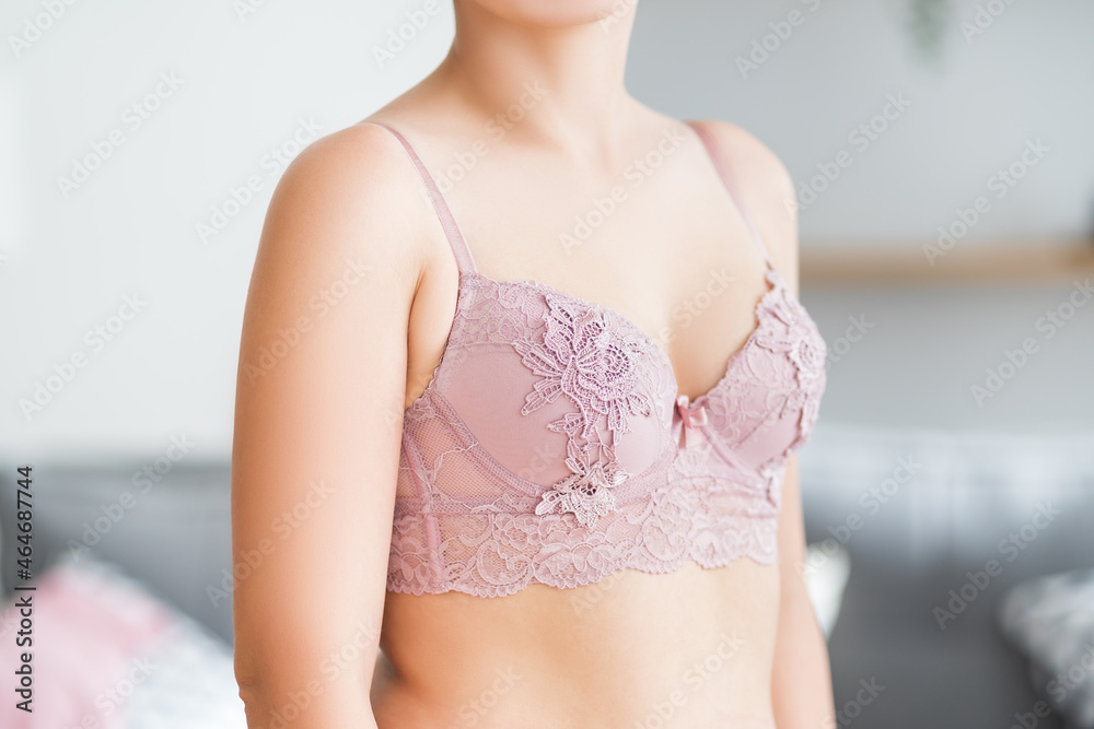 Woman in pink lace bra at home