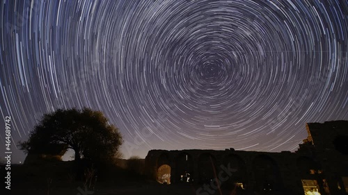 old castle in the night. Timelapse of moving star trails in night sky. A view of the stars of the Milky Way with a mountain top in the foreground. Perseid Meteor Shower observation. photo
