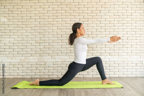 Latin woman practicing yoga on mat
