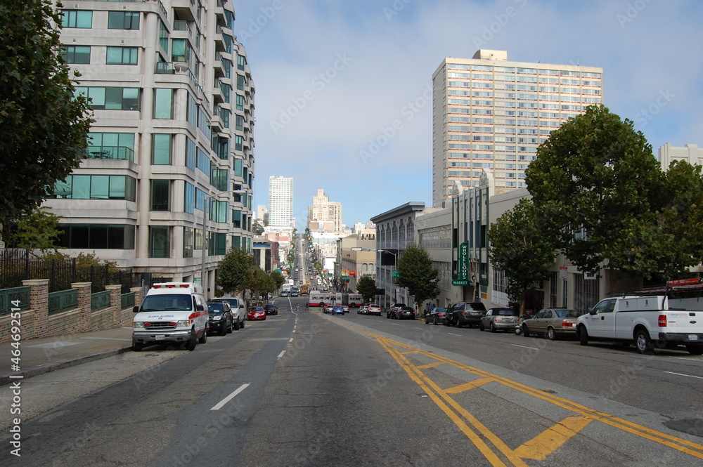 Street of San Francisco. Road on a slope with a view of skyscrapers, cars and a bus 